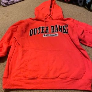 Heavily worn bright pink outer banks sweatshirt